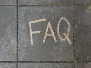 FAQ skrevet i kridt på fliser